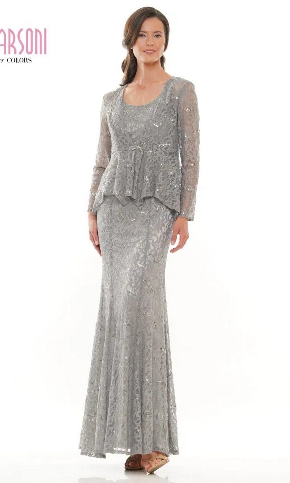 A woman stands against a plain white background wearing the Marsoni M301 long formal dress in silver, featuring lace fabric, long sleeves, and a peplum waist.